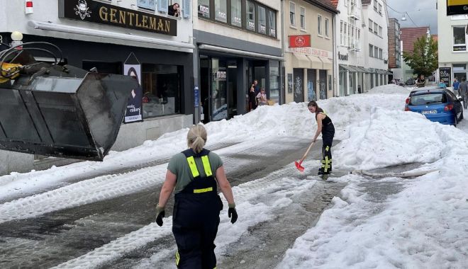 Plugurile de zăpadă, scoase pe străzile din Germania după o furtună de vară. Stratul de grindină a ajuns la 30 de centimetri