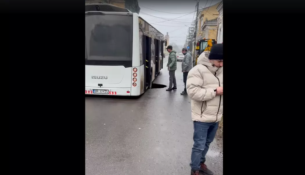 Autobuz cu pasageri, prins într-un crater apărut brusc în asfalt - 20260125-4-1769347030.webp