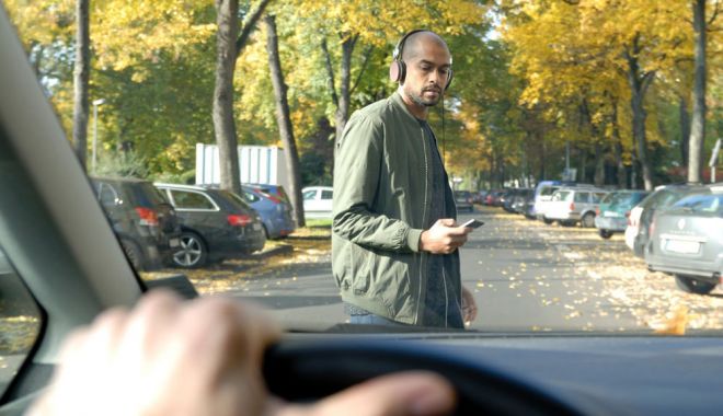 Pietonii care traversează strada cu ochii în telefon sau cu căștile în urechi ar putea fi amendați drastic
