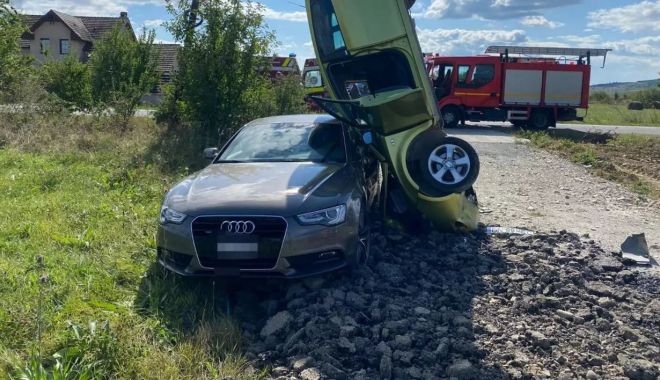 Accident spectaculos! O șoferiță a rămas cu mașina proptită în poziție verticală într-un alt autoturism