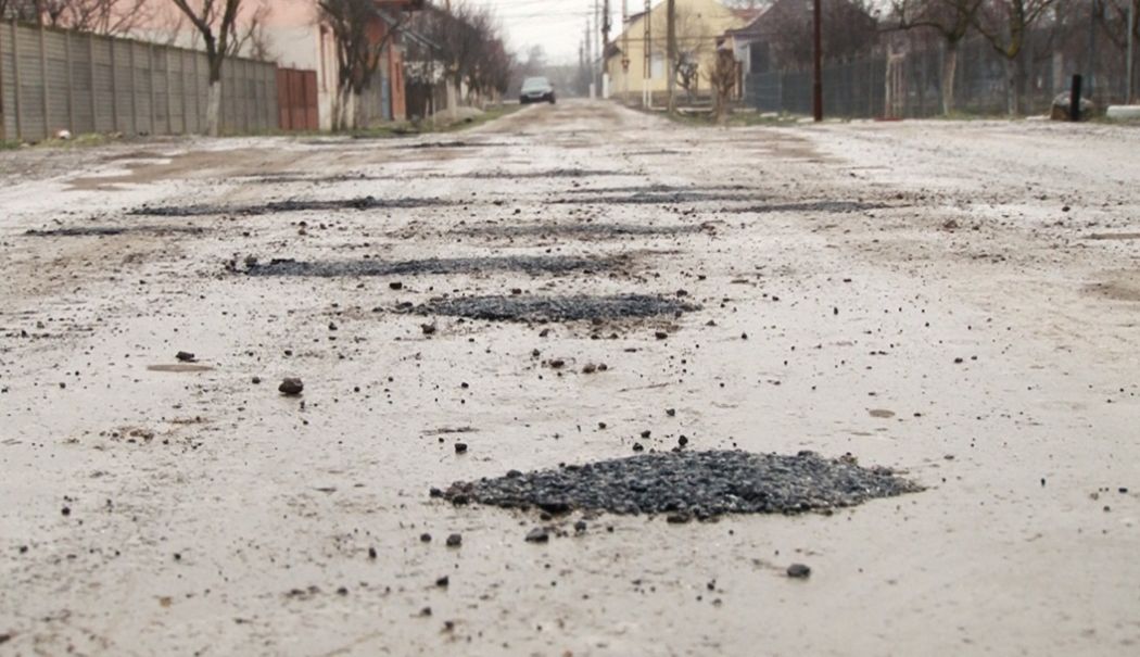 Sătul să aștepte după reparațiile primăriei, un bărbat a astupat singur gropile de pe stradă cu asfalt - drum-cu-gropi-1737380820.jpg