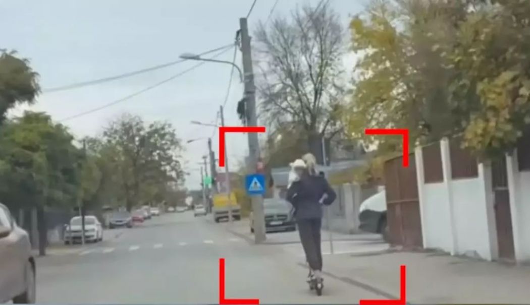 O femeie a fost filmată pe trotineta electrică cu un bebeluș în brațe