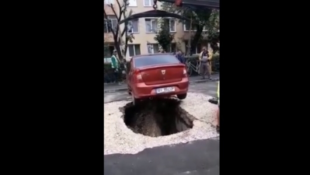 Mașină căzută într-o groapă după ce asfaltul de sub ea s-a surpat - masinainghititainasfalt39250300-1532464191.jpg