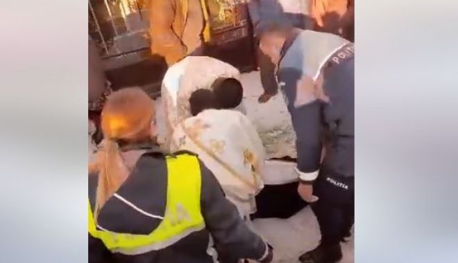 Imagini halucinante cu un preot întins pe jos, în fața porții unui cimitir, pentru a împiedica o ceremonie de înhumare