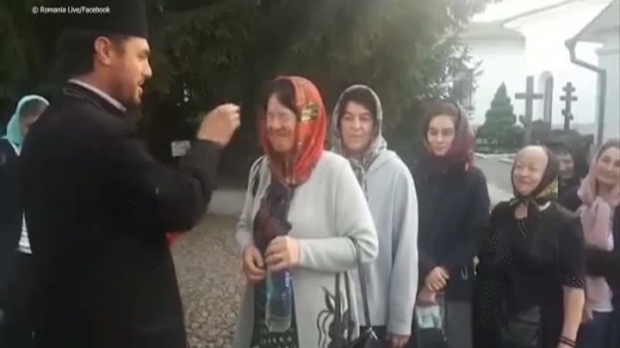 VIDEO. Credincioși plesniți peste ochi cu aghiasmă, în curtea unei mănăstiri - screenshot627565300-1557232965.jpg