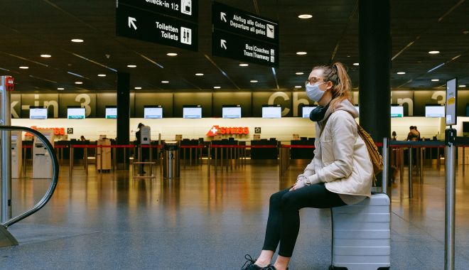 Aeroporturile nu trebuie să ceară călătorilor adeverințe de vaccinare împotriva Covid-19 - womansittingonluggagemaskpexels-1614783226.jpg
