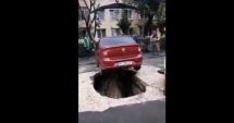 Stire din Actualitate : Mașină căzută într-o groapă după ce asfaltul de sub ea s-a surpat