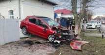 Stire din Eveniment : Accident spectaculos / Cum a ajuns un șofer cu mașina suspendată între o casă și un copac