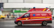Stire din Eveniment : Femeie rănită într-un accident produs în parcarea unui centru comercial. Mașină răsturnată după impact cu un parapet și un indicator