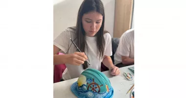 Stire din Actualitate : Compania IULIUS a invitat elevii Colegiului Național de Arte „Regina Maria” din Constanța să se exprime artistic pe un șevalet atipic – căști de protecție pe șantier